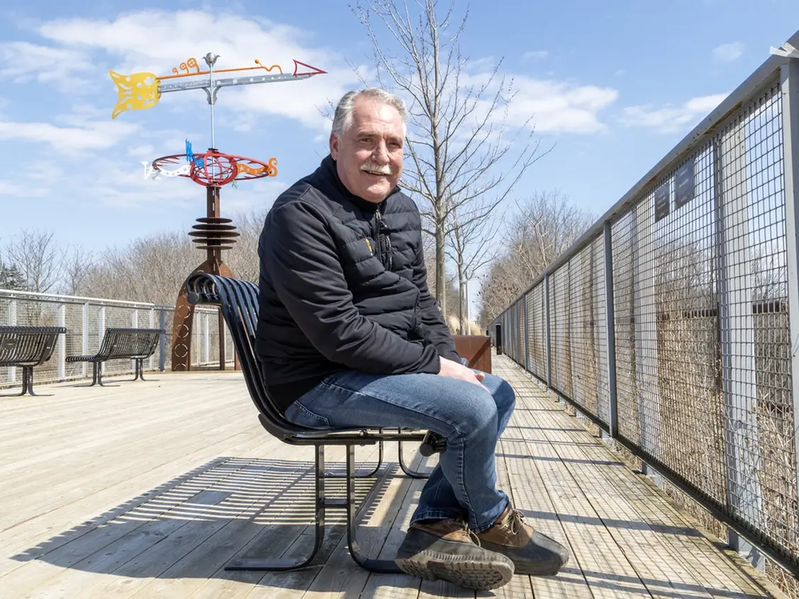 Steve Peters seated on a bench along the rail trail